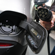FRANKFURT AM MAIN, GERMANY - SEPTEMBER 09: A journalist holds a charging cable next to the electric charging port as the fuel cap is open behind on a Mercedes-Benz GLC 300e plug-in hybrid at the Mercedes-Benz media preview at the 2019 IAA Frankfurt Auto Show on September 09, 2019 in Frankfurt am Main, Germany. The IAA will be open to the public from September 12 through 22. (Photo by Sean Gallup/Getty Images)
